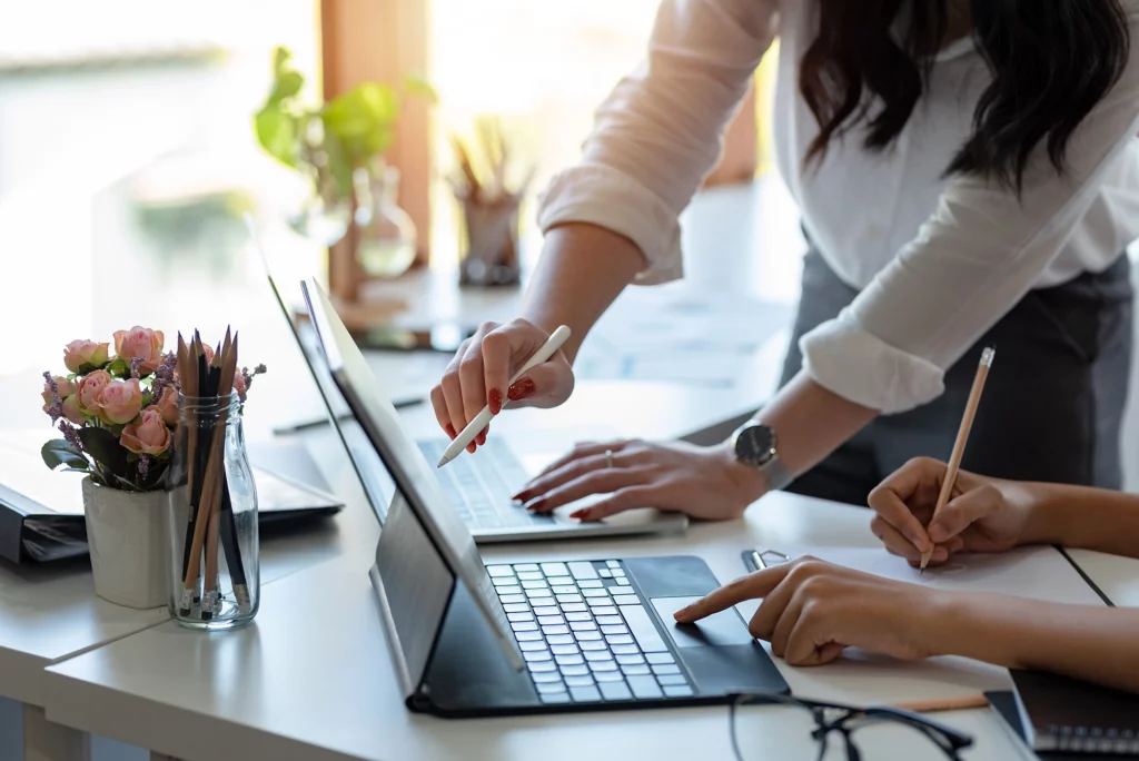 Zwei Personen arbeiten am Laptop – Symbolbild für Weiterbildung und Karriereentwicklung mit KNOLL.
